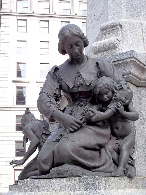 Bronze statue of Jeanne Mance holding a child and caring for a sick person